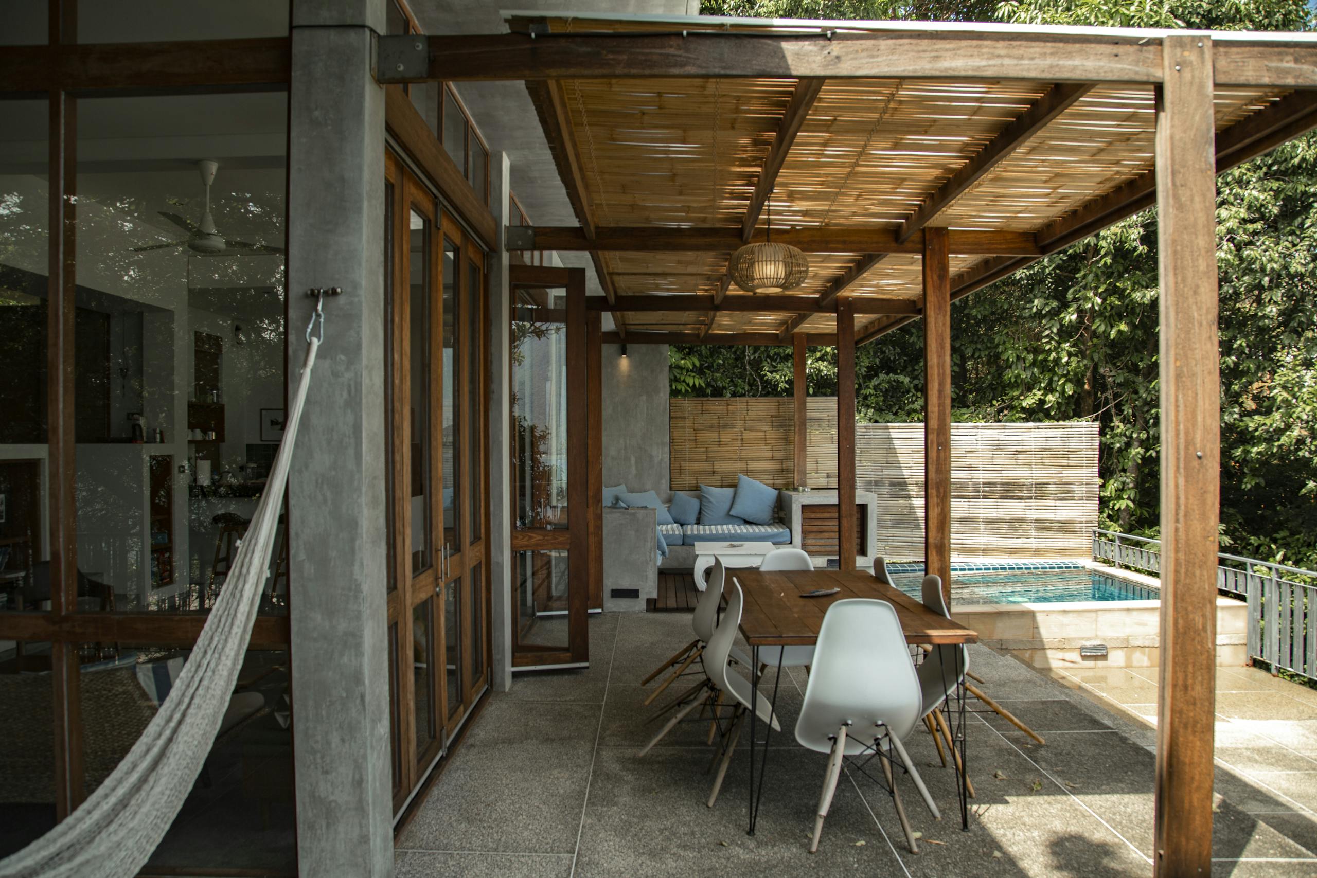 A stylish outdoor patio with wooden pergola and swimming pool, perfect for relaxation.